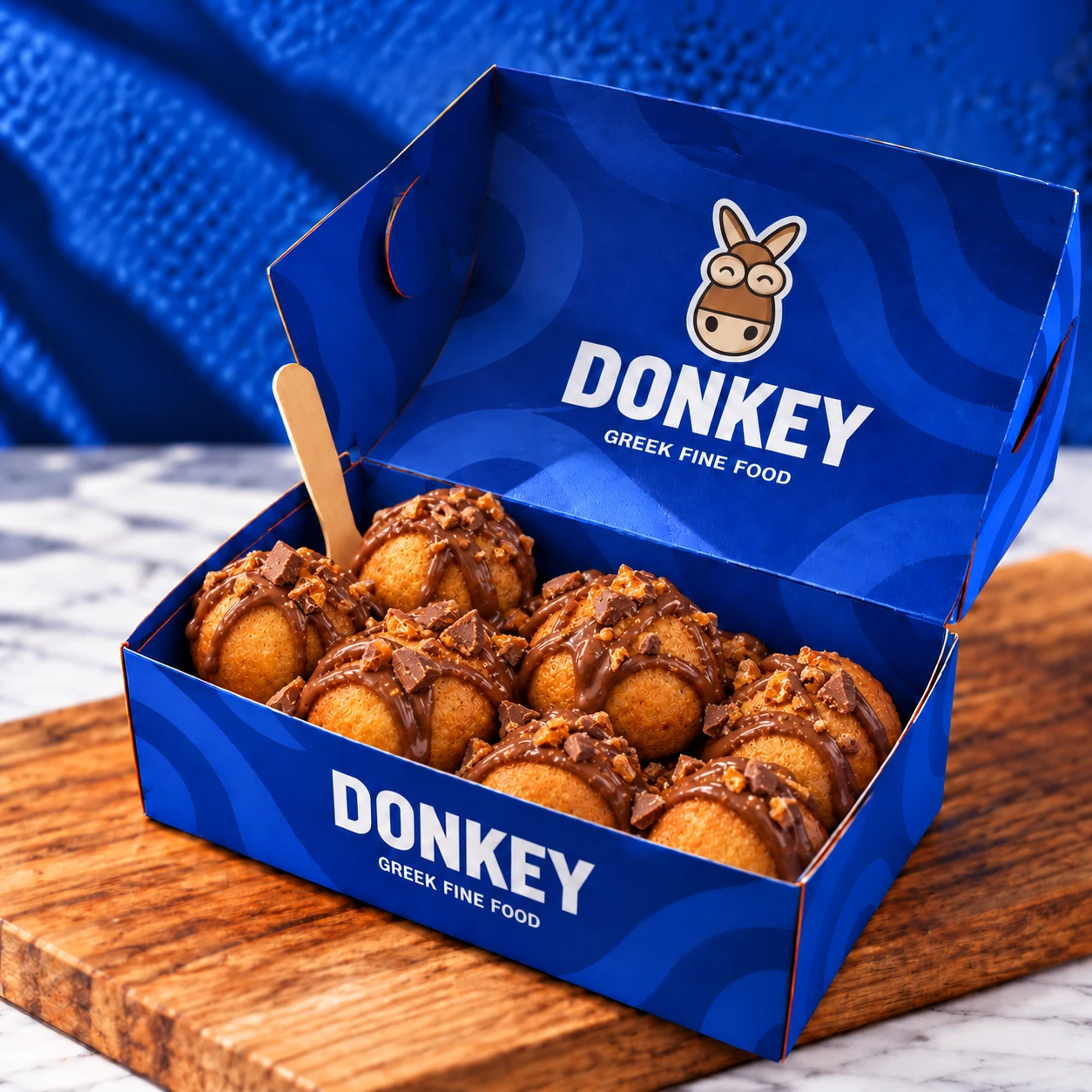 Loukoumades Daim Donkey, boîte de beignets nappés et parsemés d'éclats de Daim